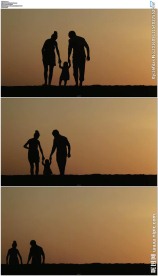 夕阳下父母牵着小孩行走剪影