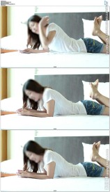 美女趴床上玩手机