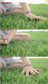 一个小女孩的手抚摸青草