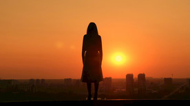 在日落时在屋顶上的女人